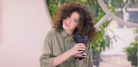 Una mujer secándose el pelo con un difusor.