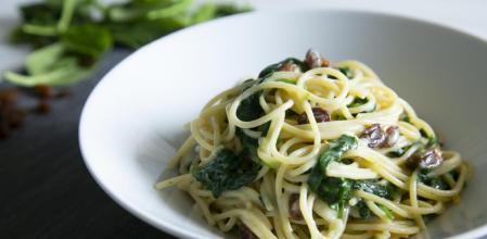 Espaguetis con espinacas, pasas y bechamel, una receta vegana muy sencilla (y rica)