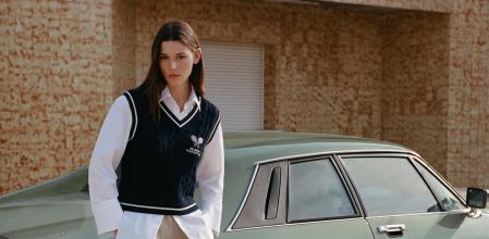 Chaleco azul marino sobre una camisa holgada y un pantalón beige de corte oversize