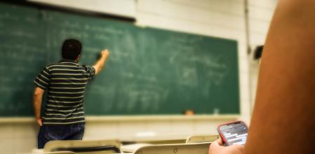 Un profesor escribe en la pizarra