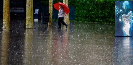 Una mujer se protege de la lluvia en Barcelona