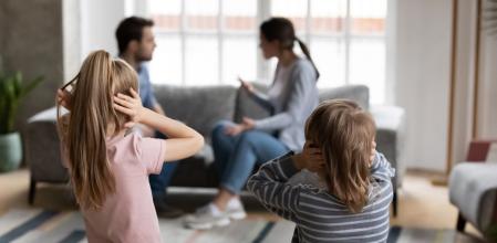 Distressed small kids brother and sister cover close ears avoid listening to parents quarrel fight at home, sad little siblings suffer from family adult conflicts or disputes affecting children health