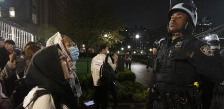 Pro-Palestine student activists face off with New York Police Department officers during a raid on Columbia University's campus at the request of Columbia University President Minouche Shafik on Tuesday evening, April 30, 2024 in New York. NYPD officers, including those from the police department's Strategic Response Group, arrested approximately 100 people as they dismantled encampments and removed individuals occupying Hamilton Hall. (Seyma Bayram via AP)