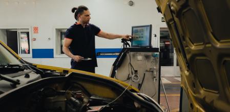 Un operario de una ITV somete un coche a inspección