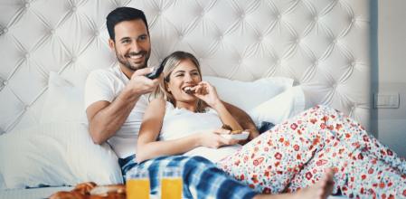Pareja en pijama disfrutando de su desayuno.