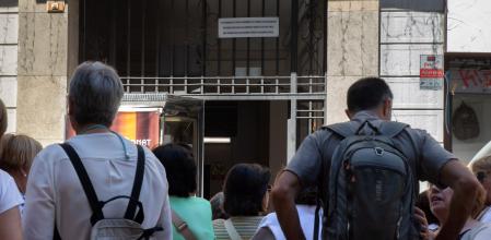 FOTO MARTI GELABERT 05/06/2024 ENTRADA DE UNO DE LOS EDIFICIOS DONDE SE HACE ALQUILER TURISTICO ILEGAL EN EL CENTRO DE BARCELONA, CON DECENAS DE TURISTAS PARADOS JUSTO DELANTE. SE PUEDE VER UN CARTEL EN EL QUE SE PROHIBE ESTA ACTIVIDAD EN LA FINCA