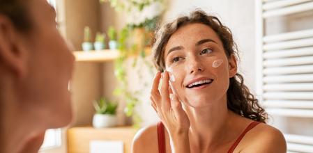 Una mujer haciendo su rutina de limpieza y cuidado facia.