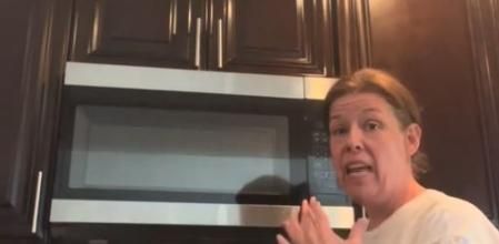 La mujer muestra su microondas