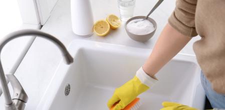 Una persona limpiando el desagüe de la cocina