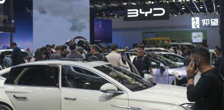 FILE - Visitors look at cars at the BYD booth during the China Auto Show in Beijing, China, Friday, April 26, 2024. The European Union threatened on Wednesday, june 12, 2024, to hike tariffs on Chinese electric vehicles, escalating a trade dispute over Beijing's subsidies for the exports that Brussels worries is hurting domestic automakers. (AP Photo/Tatan Syuflana, File)