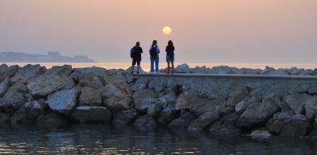 Contemplando el amanecer del sol manchado desde el espigón de Fuengirola.