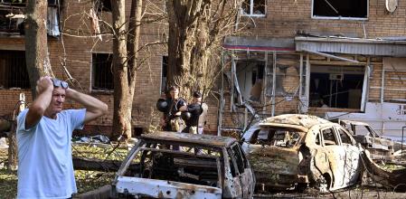A man reacts while standing next to burnt-out remains of cars in the courtyard of a multi-storey residential building, which according to local authorities was hit by debris from a destroyed Ukrainian missile, in the course of Russia-Ukraine conflict in Kursk, Russia August 11, 2024. Kommersant Photo/Anatoliy Zhdanov via REUTERS RUSSIA OUT. NO COMMERCIAL OR EDITORIAL SALES IN RUSSIA.