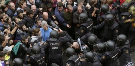 Agentes antidisturbios de la Policía Nacional forman un cordón de seguridad frente al colegio Ramón Llull de Barcelona.&nbsp;