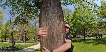 Un hombre abrazando a un árbol
