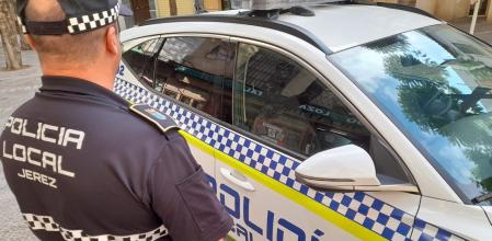 Un agente de la Policía Local de Jerez de la Frontera junto a su vehículo, en una foto de archivo