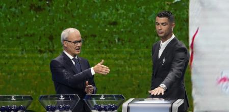 UEFA's Giorgio Marchetti directs player Cristiano Ronaldo to press a button to proceed with the Champions League, league phase, draw, in Monaco, Thursday, Aug. 29, 2024.