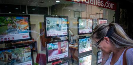 Una mujer consulta la oferta de pisos en una inmobiliaria, en Cerdanyola del Vallès&nbsp;