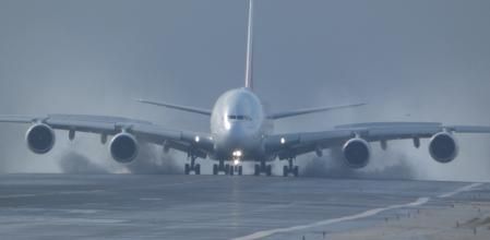 Un  A380 de Emirates levantando toda el agua de la pista en El Prat.