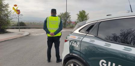 Agente de la Guardia Civil junto a su coche patrulla&nbsp;