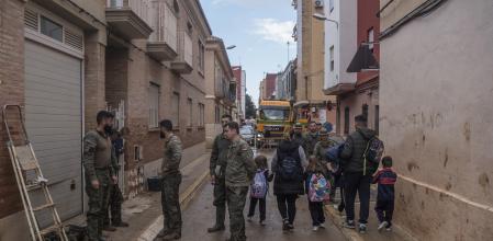 Militares junto a los alumnos que han salido del colegio 'La Inmaculada', el primero en abrir tras la DANA, a 4 de diciembre de 2024, en Paiporta, Valencia, Comunidad Valenciana (España). Más de un mes después de la DANA, los alumnos del colegio La Inmaculada han sido recibidos entre aplausos de padres, profesores y efectivos de la UME en la reapertura del centro, el primero en hacerlo en Paiporta, zona cero de la DANA.
