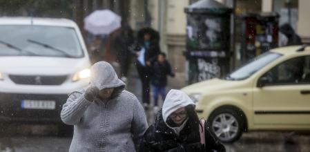 Dos personas se tapan la cabeza con la capucha de la chaqueta como consecuencia de la lluvia, a 6 de febrero de 2023, en Valencia, Comunidad Valenciana (España). El panorama que depara el tiempo en Valencia esta semana, tal como revela la previsión de la Agencia Estatal de Meteorología (Aemet) es de lluvia, fuertes vientos y mucho frío. La cota de nieve bajará en Valencia y llegará a situarse en torno a los 800 metros. Pese a que las temperaturas mínimas subirán con respecto a las registradas en los últimos días, la sensación de frío será intensa debido a un desplome de las temperaturas.