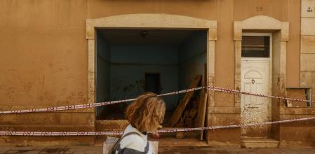 Una mujer camina junto a una zona cubierta de barro, a 28 de noviembre de 2024, en Paiporta, Valencia (Comunidad Valenciana). El pasado 29 de octubre, la DANA arrasó varias zonas de España siendo la provincia de Valencia la más afectada, donde el temporal dejó más de 220 fallecidos a su paso. Dentro de Valencia, Paiporta fue uno de los municipios más afectados. La reparación y reconstrucción de las infraestructuras dañadas por las inundaciones y su gestión ha sido cifrada en más de 2.600 millones de euros por la Conselleria de Medio Ambiente, Infraestructuras y Territorio, cantidad a la que se suma el importe del Ministerio de Transportes y Movilidad Sostenible habilitado hasta ahora de 123 millones para recuperar la movilidad en Valencia y 185 millones para reparar la red de Cercanías y alta velocidad.