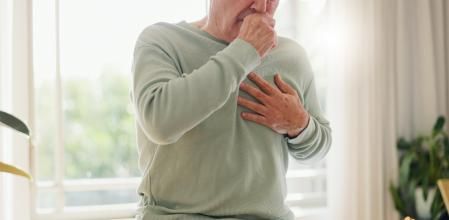 Coughing, sick and a person feeling chest for pain, heart attack or health problem at home. Healthcare, covid and a man with a cold, flu or virus of the lungs, infection or symptom of a disease