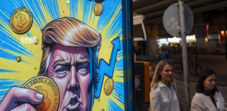 A cartoon image of US President-elect Donald Trump holding a Bitcoin token to mark the cryptocurrency reaching over $100,000 displayed at a Coinhero store in Hong Kong, China, on in Hong Kong, China, on Thursday, Dec. 5, 2024. Trump's pick of a crypto proponent to be the next head of the US securities regulator liftedBitcointo $100,000 for the first time as traders warmed to the prospect of relaxed regulations. Photographer: Justin Chin/Bloomberg