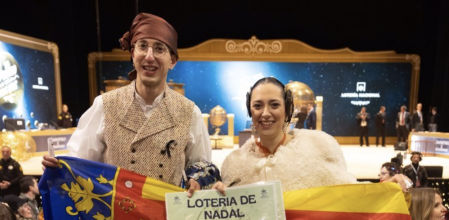 Una joven vestida de fallera, entre las primeras en entrar al Teatro Real para ver el Sorteo de Navidad