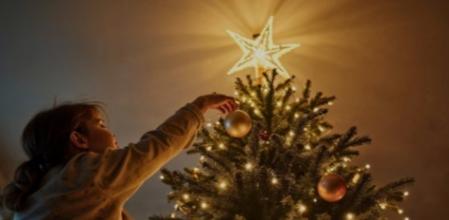 Una niña colocando las luces de Navidad