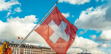 Imagen de la bandera de Suiza con vistas a la ciudad de Ginebra