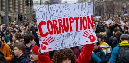 A woman holds a placard reading 