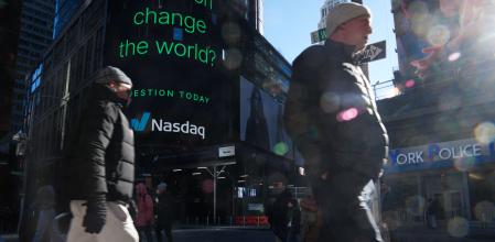 People walk by the Nasdaq headquarters in Times Square, as Nasdaq fell nearly 4 percent this morning on January 27, 2025 in New York City. European and Asian stock markets mostly slid Monday and Wall Street was forecast to open sharply lower on talk that a cheaper Chinese generative AI program, DeepSeek, can outperform big-name rivals, notably in the United States. (Photo by Bryan R. SMITH / AFP)