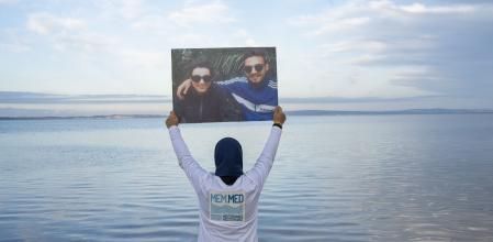 Una persona posa con los retratos de sus familares desaparecidos&nbsp;