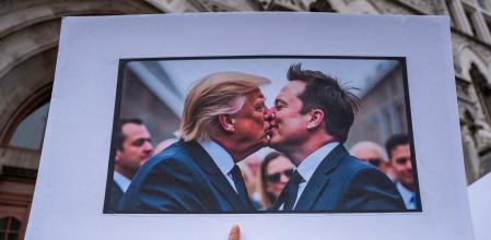 A protester holds a sign with an AI image depicting President Donald Trump and tech billionaire Elon Musk during a 50501 Movement protest against Project 2025 and the executive orders of U.S. President Donald Trump, on Broadway in Nashville, Tennessee, U.S., February 5, 2025. REUTERS/Seth Herald