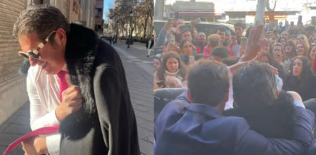 Juan Pablo, con abrigo y gafas de sol, es escoltado por sus cómplices mientras recibe aplausos y flashes a la salida del hotel