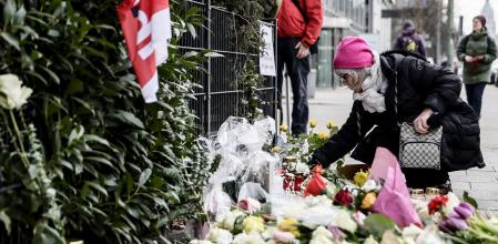 Una mujer deposita unas flores en el altar improvisado por las víctimas y heridos, en Múnich.
