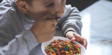 Un niño comiéndose un bol de cereales azucarados de colores