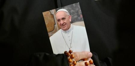 Una monja sosté una imatge del papa Francesc durant una oració del rosari per la salut del Pontífex a la plaça de Sant Pere