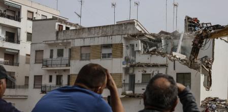 Vecinos observan el derribo de viviendas con maquinaria pesada, a 24 de febrero de 2025, en Chiva, Valencia. 