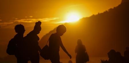 Un grupo de personas caminan durante el atardecer este pasado miércoles, en la playa de Ipanema en Río de Janeiro (Brasil), que sufre una fuerte ola de calor, con temperaturas cercanas a los 40°C