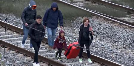 Pasajeros evacuados de un tren averiado, caminan por las vías en L'Hospitalet