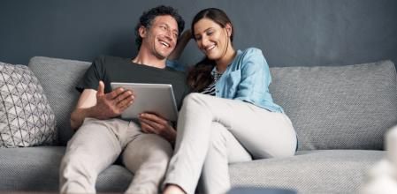 Una pareja, mirando alegremente ofertas en Amazon