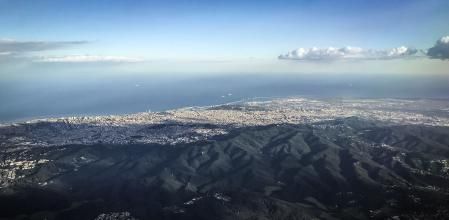 Vista aérea de Collserora, el gran pulmón verde metropolitano, y al fondo, la ciudad de Barcelona y parte del Baix Llobregat