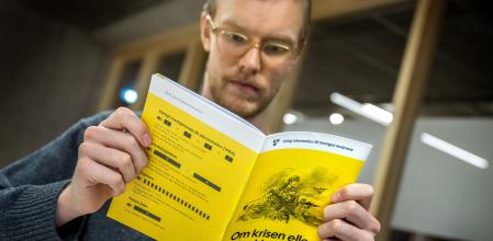 Un ciudadano sueco con un folleto, ‘Si llega una crisis de guerra’, en noviembre del 2024