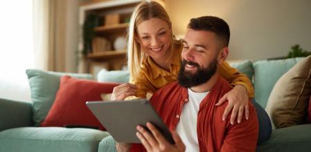 Una pareja feliz consulta las mejores ofertas del día en Amazon