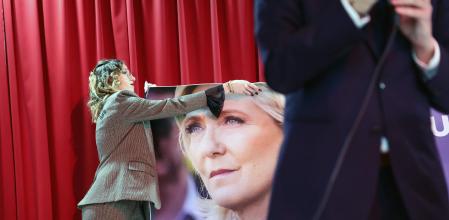 TOPSHOT - A participant hangs a poster during a gathering in support of President of Rassemblement National parliamentary group Marine Le Pen, after she was convicted of a fake jobs scheme at the EU parliament, in Marseille on April 5, 2025. Marine Le Pen was given a prison term and fine on March 31, 2025, a verdict that sparked an international echo. Le Pen said that she would use all possible legal avenues to stand in 2027 elections despite a ban on her running and hailed the promise of a speedy appeal of her criminal conviction. (Photo by Clement MAHOUDEAU / AFP)