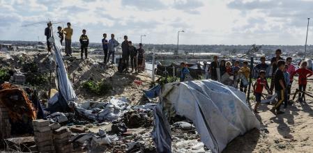Palestinos junto a tiendas de campaña destruidas por un bombardeo del Ejército de Israel contra Jan Yunis, en el sur de la Franja de Gaza&nbsp;