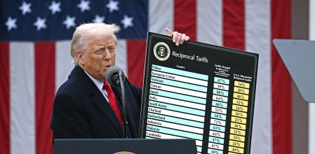 US President Donald Trump delivers remarks on reciprocal tariffs as US Secretary of Commerce Howard Lutnick holds a chart during an event in the Rose Garden entitled 