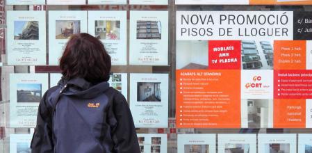 Una mujer consulta la oferta de una inmobiliaria en Girona